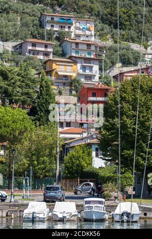 LAGO D'ISEO, LOMBARDIA/ITALIA - AGOSTO 15 : Vista di edifici e barche lungo la riva del lago d'Iseo in Lombardia il 15 agosto 2020. Due persone non identificate Foto Stock