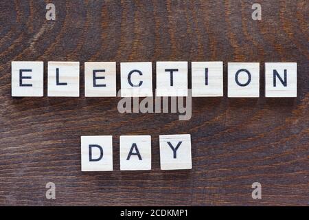 Blocchi di legno con l'iscrizione 'giorno dell'elezione', lettere di legno chiaro su uno sfondo di legno scuro Foto Stock
