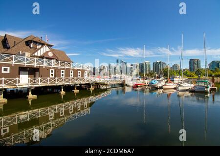 Vancouver Rowing Club House a Stanley Park. La vista sulla casa dello yacht e le barche a vela che si riflettono in acqua. Il paesaggio urbano sullo sfondo. Foto Stock