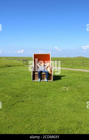 Uomo sulla sedia spiaggia Foto Stock