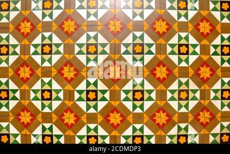 Mosaico di piastrelle Peranakan come si trova in genere nelle tradizionali botteghe cinesi. Un pattern geometrico e simmetrico che si ripete di arancione, marrone, giallo, blac Foto Stock
