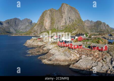 Case in legno rosso Rorbu, Rorbu cabine dei pescatori, presso il Reine Fjord, Reinefjords, dietro la catena montuosa di Festhaeltinten, Hamnoy Foto Stock