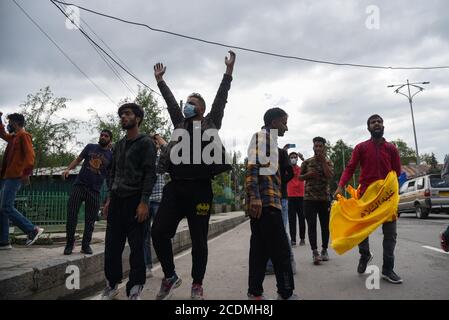 I lutto di Kashmiri shia detengono la bandiera mentre gridano gli slogan religiosi durante la processione di muharram. Le autorità hanno imposto severe restrizioni in molte aree di Srinagar per vietare la processione dell'8° Muharram. Foto Stock