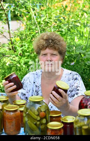 Casalinga matura con un cibo in scatola per l'inverno Foto Stock