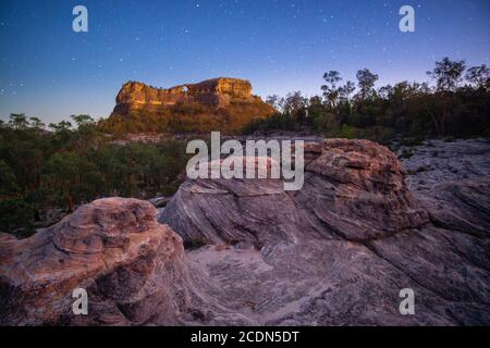 Formazione di pietra arenaria agli albori con Spyglass Peak sullo sfondo. Salvator Rosa Sezione Parco Nazionale Carnarvon, Queensland, Australia Foto Stock