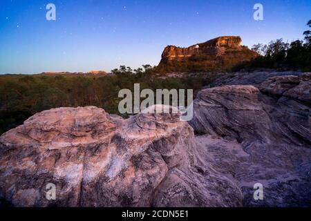 Formazione di pietra arenaria agli albori con Spyglass Peak sullo sfondo. Salvator Rosa Sezione Parco Nazionale Carnarvon, Queensland, Australia Foto Stock