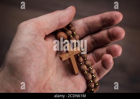 croce di legno in mano con il fuoco sulla croce Foto Stock