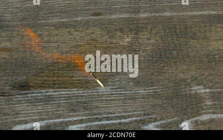 Piccolo fuoco su sfondo di legno. Ustioni di alcool Foto Stock