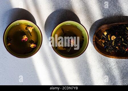 Concetto di bevande a base di tè in stile asiatico con tazze da tè e. bastoncini di pollo su sfondo bianco in cemento con spazio per la copia Foto Stock