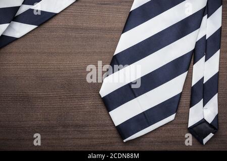 cravatta nera e bianca a righe su tavolo di legno Foto Stock