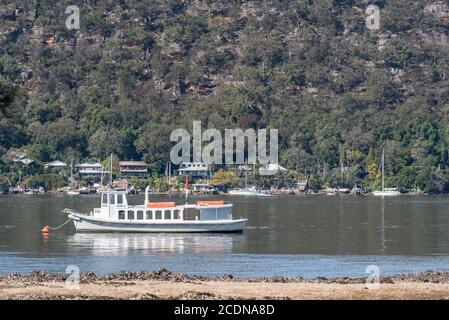 Uno storico traghetto fluviale ormeggiato vicino a Bradleys Beach, Dangar Island nel fiume Hawkesbury e case a Little Wobby, 55 km a nord di Sydney, Australia Foto Stock