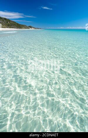 Sabbia bianca e acqua limpida sotto il cielo blu, vicino a Awinya Creek, riva occidentale di Fraser Island, Hervey Bay Queensland Australia Foto Stock