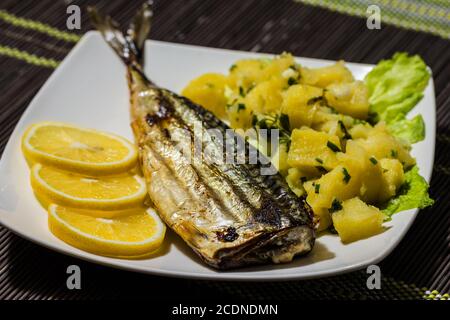 Grigliata di sgombro con insalata di patate e limone Foto Stock