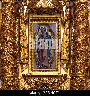 Dipinto di nostra Signora di Guadalupe Vergine Maria in una foglia d'oro decorazione altare in stile barocco all'interno della Cattedrale di Santo Domingo, Oaxaca, Messico. Foto Stock