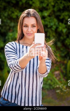 donna su uno smartphone in una strada urbana Foto Stock