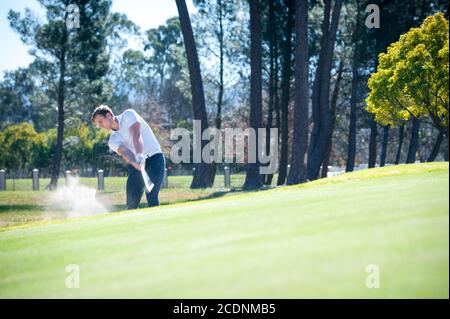 immagine di un golfer che gioca un chip sparato sul verde su un campo da golf in sud africa Foto Stock