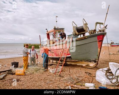 I pescatori che sbarcano la loro cattura di granchi Spider sulla spiaggia di ciottoli Stade nella città vecchia di Hastings, East Sussex England UK - Barca da pesca di granchio Foto Stock