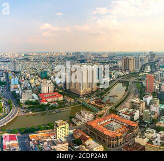 Vista dall'alto dello skyline centrale di Saigon durante il pomeriggio nelle aree urbane Con edifici alti lungo il fiume che mostra il paese di sviluppo in ho Chi Minh City Foto Stock