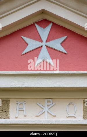 Croce di Malta, simbolo dell'ordine medievale di San Giovanni, sopra i simboli cristiani ("Pace di Cristo" circondata da "Alfa" e "Omega") Foto Stock