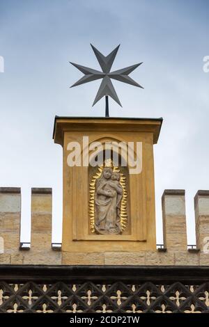 Croce di Malta, simbolo dell'ordine medievale di San Giovanni, sopra una statua della vergine Maria e del bambino Foto Stock