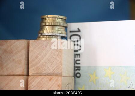 2 pile di monete in euro e 100 euro di bolletta. Il concetto di crescita del profitto aziendale Foto Stock