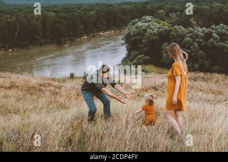 Genitori che camminano con il bambino famiglia all'aperto vacanza madre e padre con il bambino toddler sano stile di vita campagna natura fiume e foresta visualizza Foto Stock