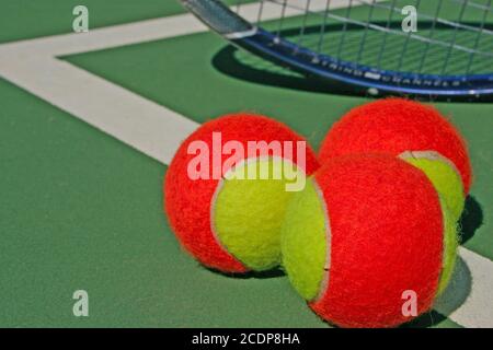 Tre palle da tennis e una racchetta Foto Stock