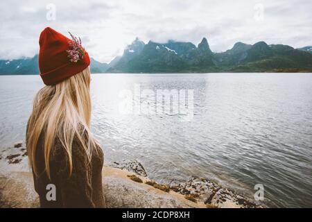 Donna che viaggia da sola in Norvegia vacanza estiva all'aperto stile di vita sano ragazza bionda in cappello rosso e fiori godendo di vista Delle isole Lofoten Foto Stock