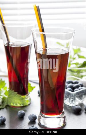 Bicchieri con succo di ribes nero fresco. Bog mirtillo e balsamo di limone Foto Stock