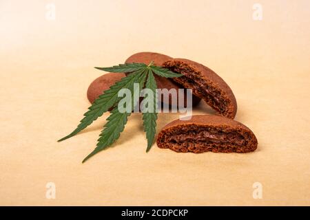 dolci con cannabis, biscotti al cioccolato con foglie verdi di marijuana. Foto Stock