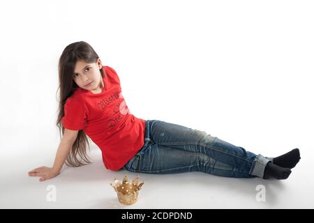 Ragazza giovane in una T-shirt rossa con slogan e cheeky principessa corona Foto Stock