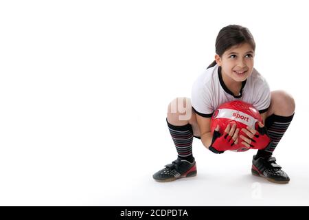 Ragazza giovane in abbigliamento da calcio con camicia Germania che tiene un calcio Foto Stock