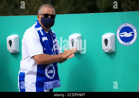 Un fan sanitizza le mani prima dell'amichevole pre-stagione all'AMEX Stadium di Brighton, dove fino a 2500 tifosi sono stati autorizzati a guardare la partita dopo che il governo ha annunciato un'ulteriore serie di eventi sportivi che saranno utilizzati per pilotare il ritorno sicuro degli spettatori. Foto Stock