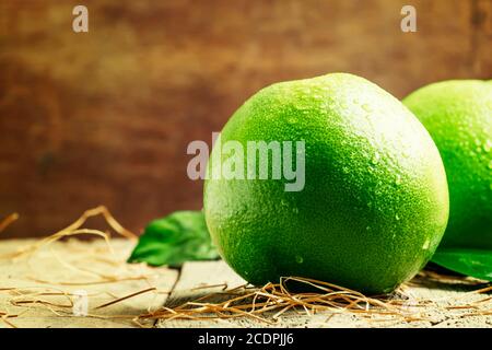 Pomelo sulla vecchia tavola di legno, fuoco selettivo Foto Stock