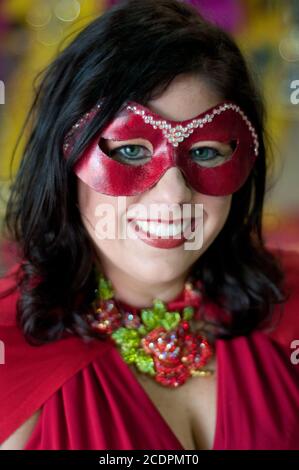 Un ritratto di una giovane donna che indossa un costume rosso di Mardi Gras e maschera oculare durante il festival a Shreveport, Louisiana, Stati Uniti. Foto Stock