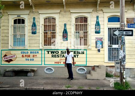 Un residente del quartiere Marigny-Bywater si trova accanto ad un piccolo negozio di alimentari, a New Orleans, Louisiana. Foto Stock