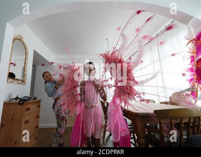 Notting Hill Carnival bambino ambasciatore A'ha Morris, 12, è aiutato nel suo costume di Carnevale 2020 da sua mamma Honey, nella loro casa a Notting Hill, Londra. Foto Stock