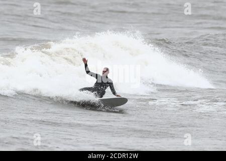 Un surfista ama le acque aspro di Scarborough, nello Yorkshire settentrionale. Data immagine: Sabato 29 agosto 2020. I previsori prevedono che questo lunedì di festa della Banca potrebbe essere il più freddo mai registrato per alcune parti del Regno Unito, poiché si prevede che le temperature siano ben al di sotto della media per il periodo dell'anno. Guarda la storia di PA tempeste DI TEMPO. Il credito fotografico dovrebbe essere: Danny Lawson/PA Wire Foto Stock