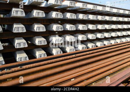 Nuove rotaie e traversine. Le rotaie e le traversine sono impilate l'una sull'altra. Ristrutturazione della ferrovia. Ferrovia per il treno Foto Stock