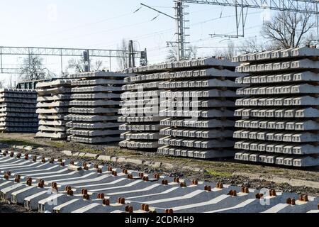 Nuove rotaie e traversine. Le rotaie e le traversine sono impilate l'una sull'altra. Ristrutturazione della ferrovia. Ferrovia per il treno Foto Stock