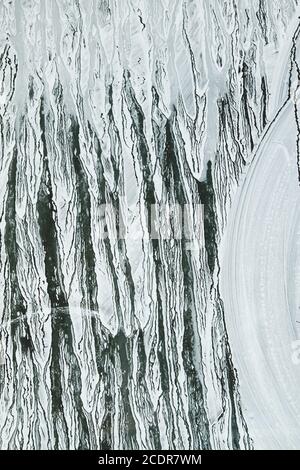 Tratti di vernice bianca su una vetrina, sfondo astratto Foto Stock