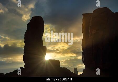 Vista di buttes, nuvole e guglie con sunburst nella Monument Valley, Utah, USA. Foto Stock
