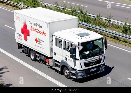 Tedesco Red MAN TGL camion in autostrada. La Croce Rossa tedesca, o DRK, è la Società Nazionale della Croce Rossa in Germania. Foto Stock