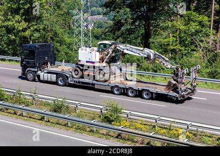 Veicolo DAF XF con pianale e escavatore eurovia in autostrada. Foto Stock