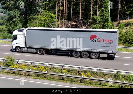 Veicolo Volvo FH con rimorchio Girteka sul lato del marciapiede in autostrada. Foto Stock