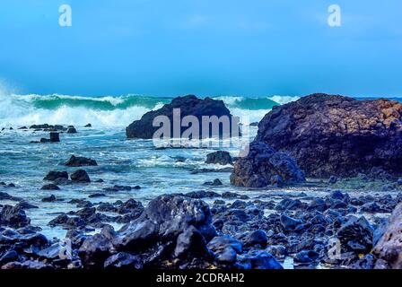 Rottura di onde e rocce vulcaniche sulla costa vicino a Orzola, Lanzarote, Spagna. Foto Stock