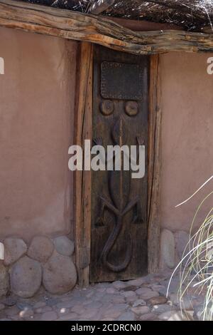 Eco friendly adobe edificio con porta in legno decorato con lucertola endemica è solo uno dei San Pedro de Atacama, s buoni hotel. Foto Stock