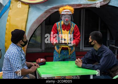 Bekasi, Indonesia. 29 Agosto 2020. Un barista e un clown (AKU Badut Indonesia) servono per i clienti presso il loro bar a Bekasi, West Java, Indonesia, il 29 agosto 2020. Il clownhose indonesiano ha scelto di avventurarsi nel business culinario a causa della mancanza di posti di lavoro di intrattenimento durante l'epidemia di COVID19. Parte dei profitti del bar sarà utilizzata per finanziare le loro attività sociali. (Foto di Evan Praditya/INA Photo Agency/Sipa USA) Credit: Sipa USA/Alamy Live News Foto Stock