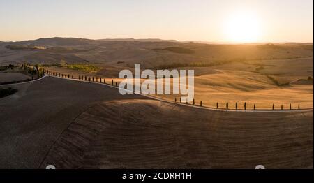 Panorama aereo di splendidi tramonti sulle colline toscane, fattorie, strade fiancheggiate da cipressi Foto Stock