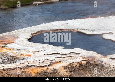 Piscina termale di South Scalloped Springs con acqua gorgogliante accanto al fiume Firehose nel Parco Nazionale di Yellowstone. Foto Stock